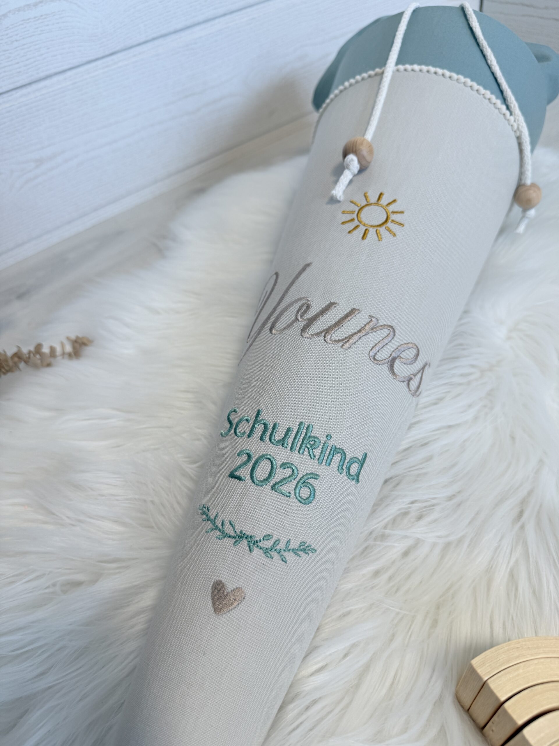 Stickerei auf der Schultüte mit Sonne, Namen Younes, Schulkind 2026, Zweig und Herz