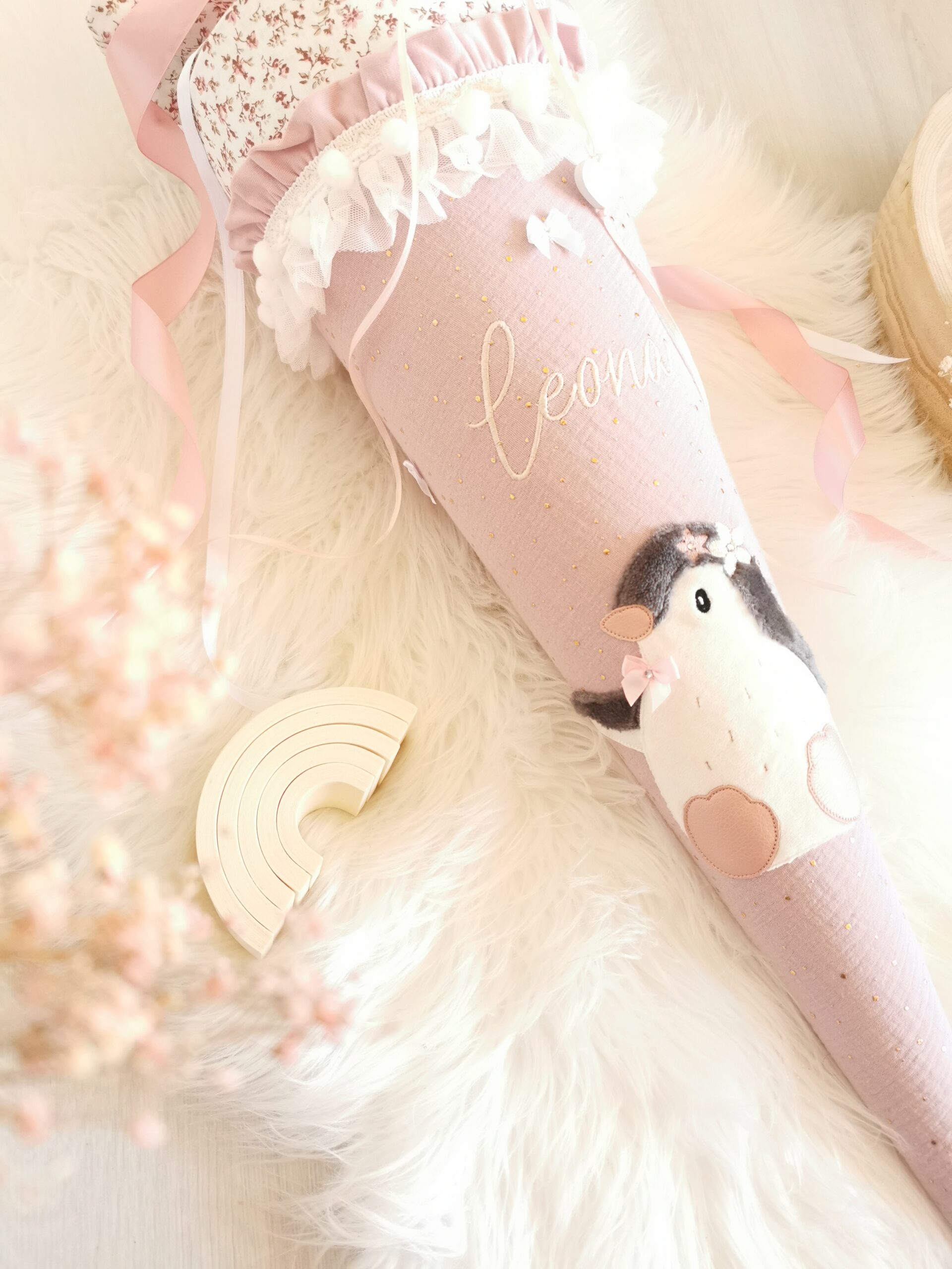 Vorderansicht der personalisierten Pinguin-Schultüte Leona mit rosa Schleife und Rüschen