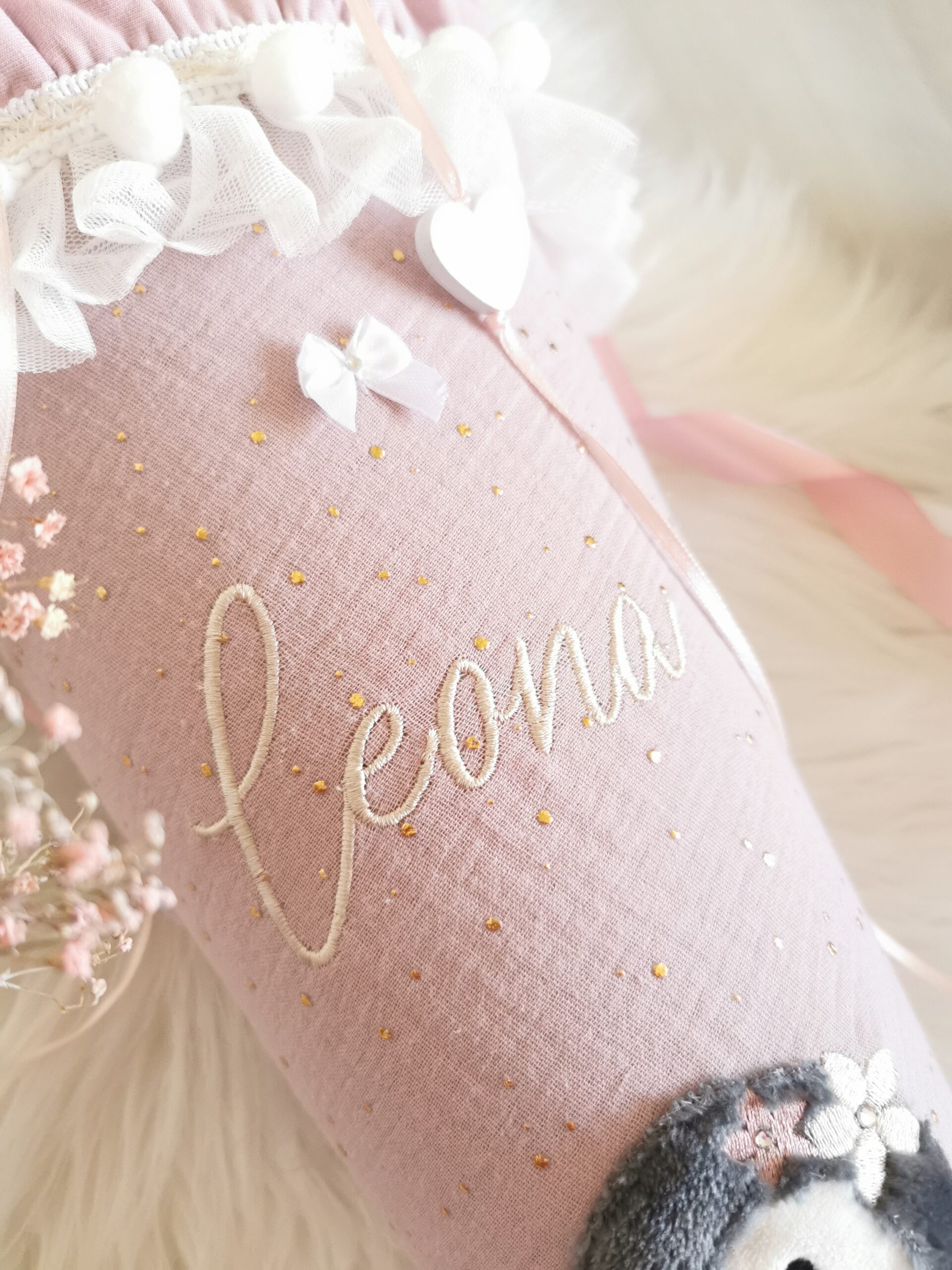 Vorderansicht der personalisierten Pinguin-Schultüte Leona mit rosa Schleife und Rüschen