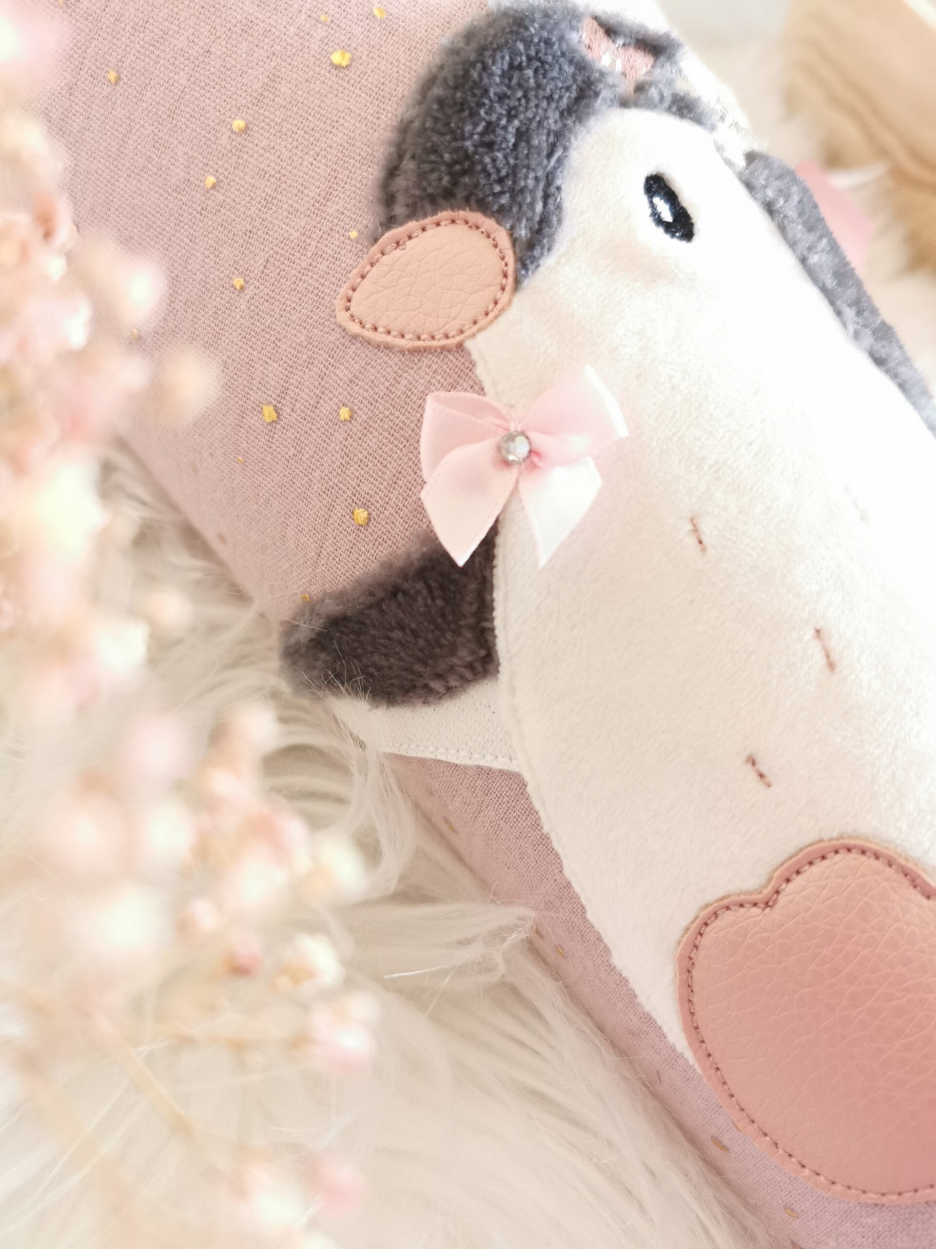 Weiche Pinguinapplikation mit weißem Bauch, rosa Fuß und Schleife auf der Stoffschultüte