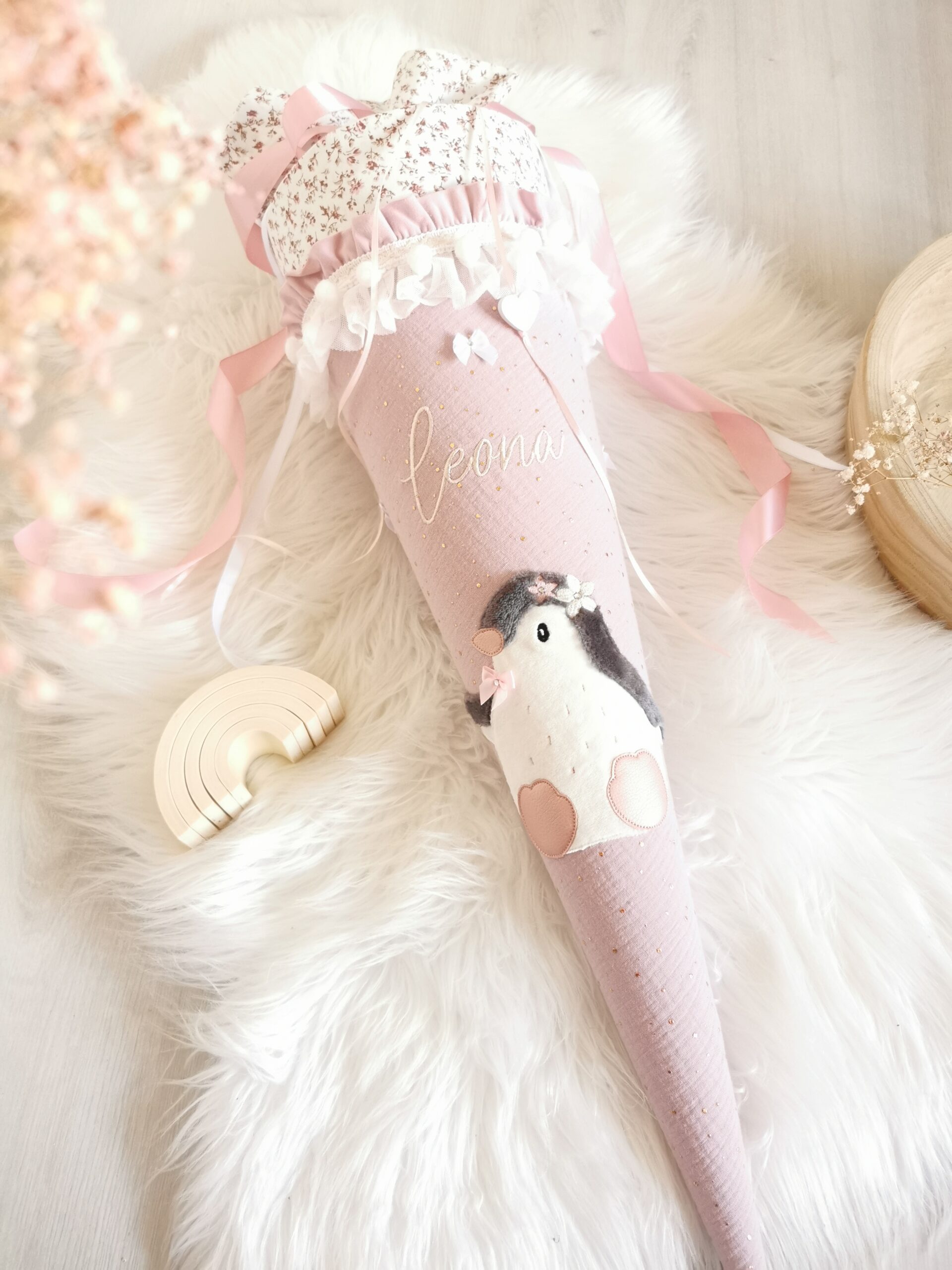 Personalisierte Pinguin-Schultüte mit rosa Satinbändern und weißer Rüschenverzierung